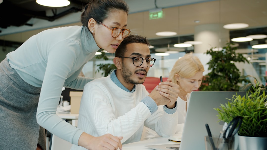 Professionisti che discutono flussi di lavoro davanti a uno schermo di computer
